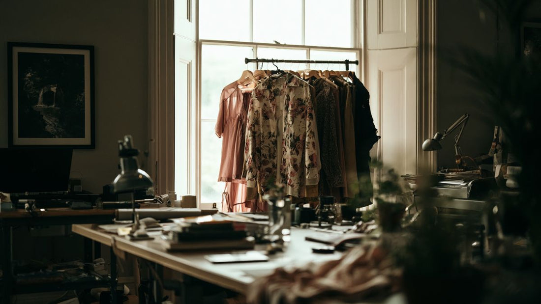 An independent designer's studio with garments on a rail, the working environment behind craft-led fashion